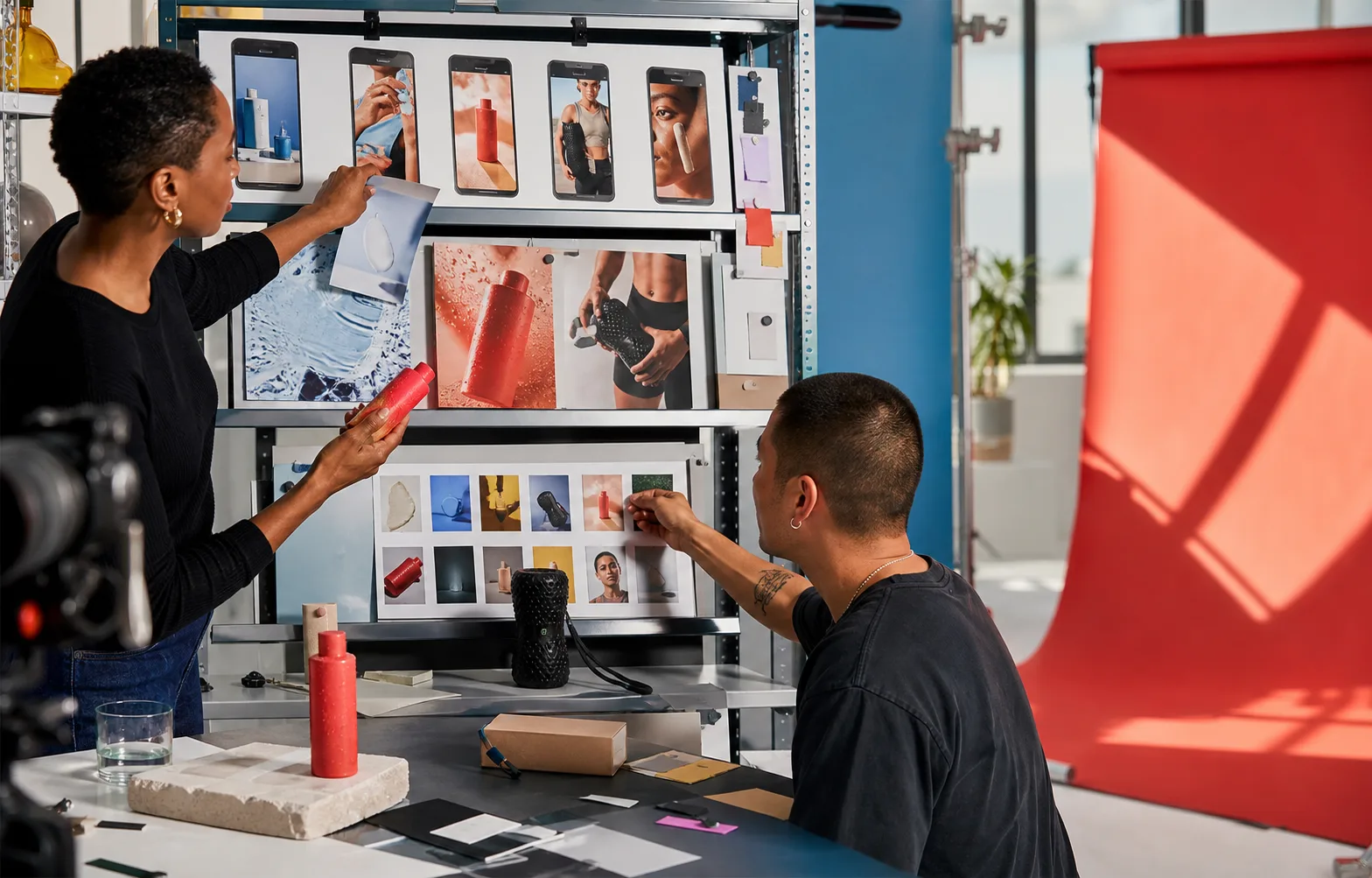 Creative strategists compare product-ad concepts on a studio test shelf.